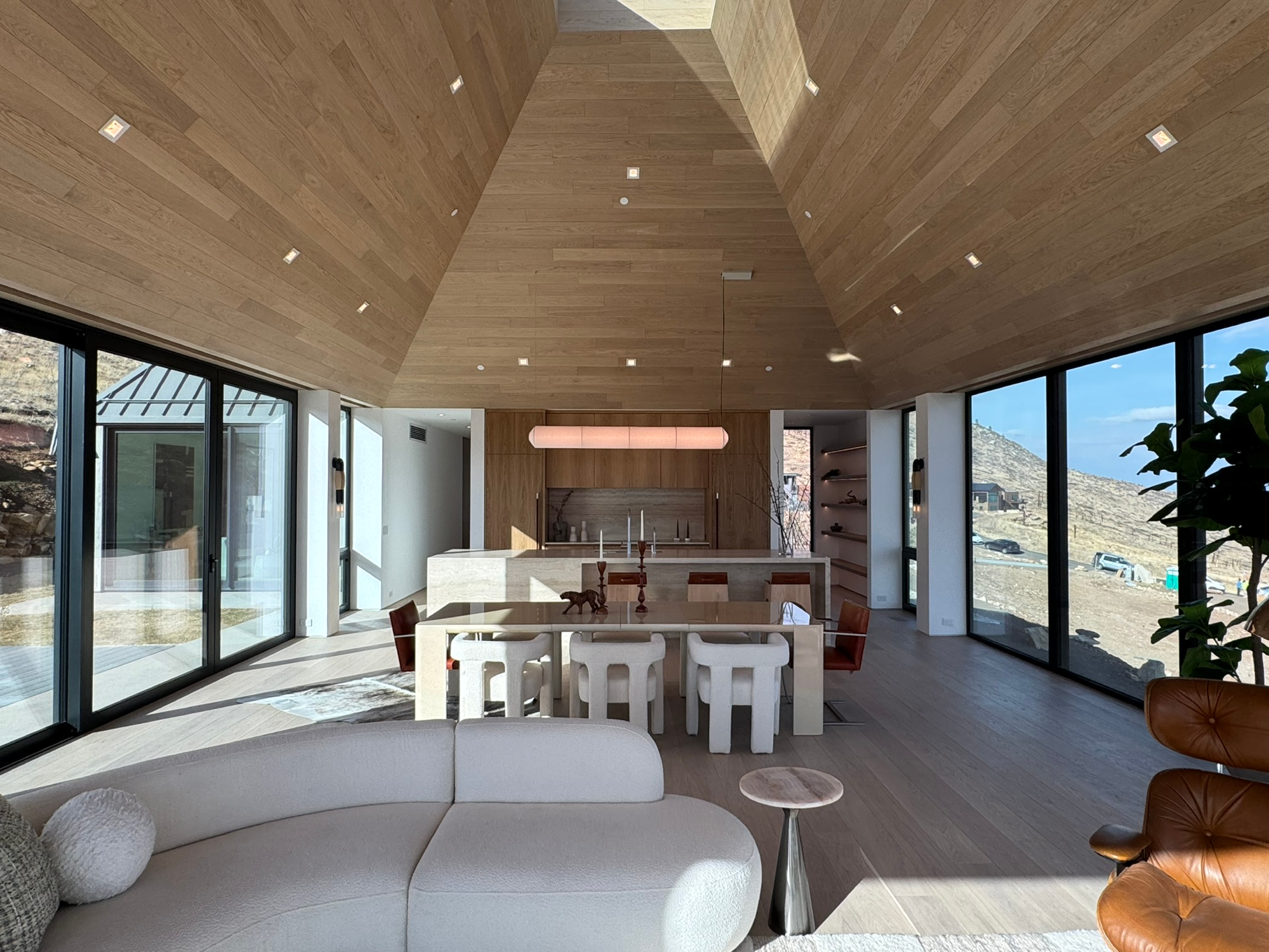 Completed modern interior with vaulted wood ceiling and expansive glazing